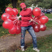 промоутер распространяет брэндированные воздушные шарики на палочках